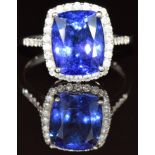 A platinum ring set with a cushion cut tanzanite of approximately 4ct surrounded by diamonds, with