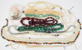 A collection of beaded necklaces including two strands of cherry amber, cultured pearl necklaces,