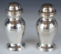 Pair of George V hallmarked silver peppers of plain bulbous form, London 1914, maker Edward
