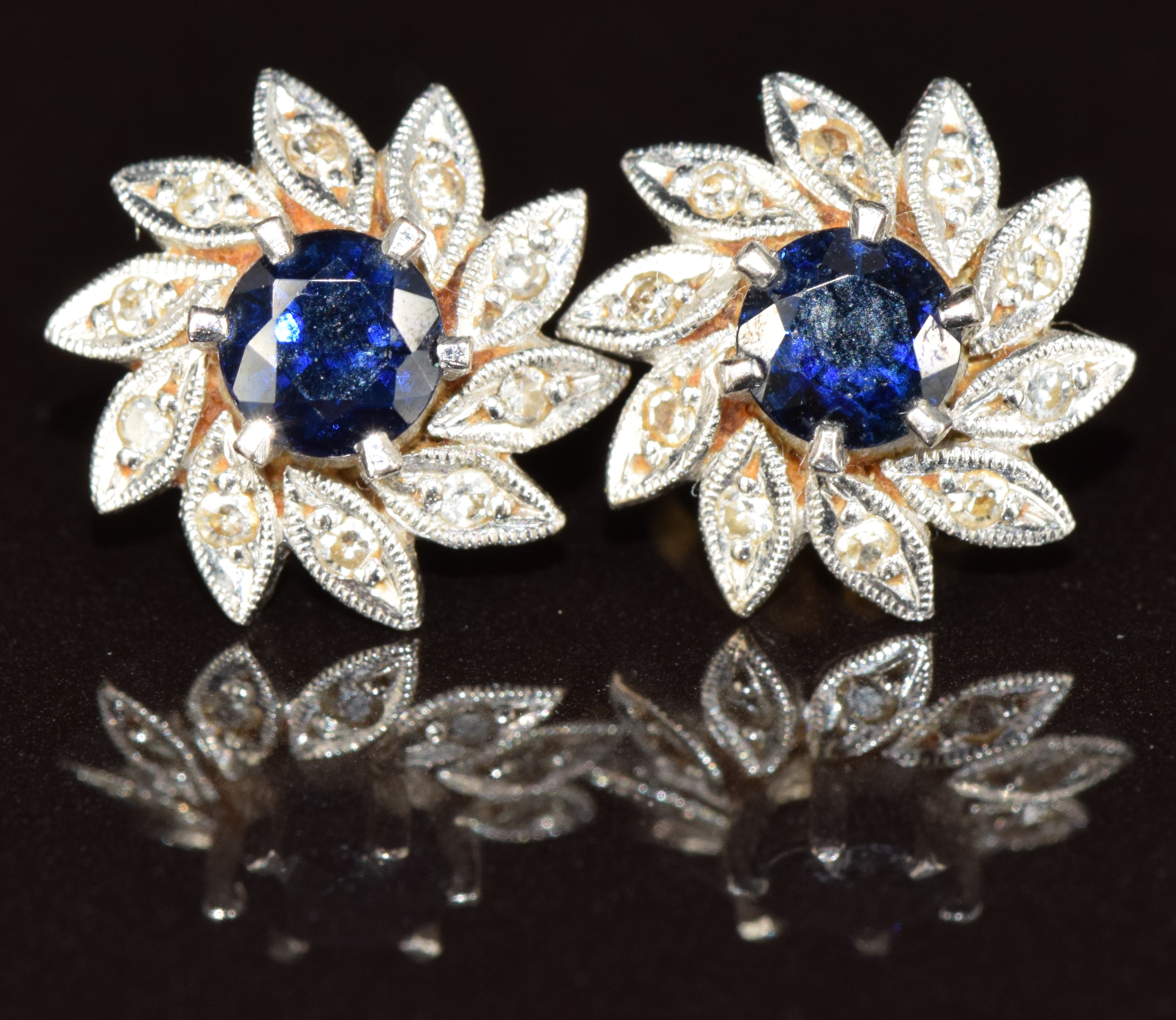 A pair of 18ct white gold earrings each set with a sapphire surrounded by diamonds, 2.6g