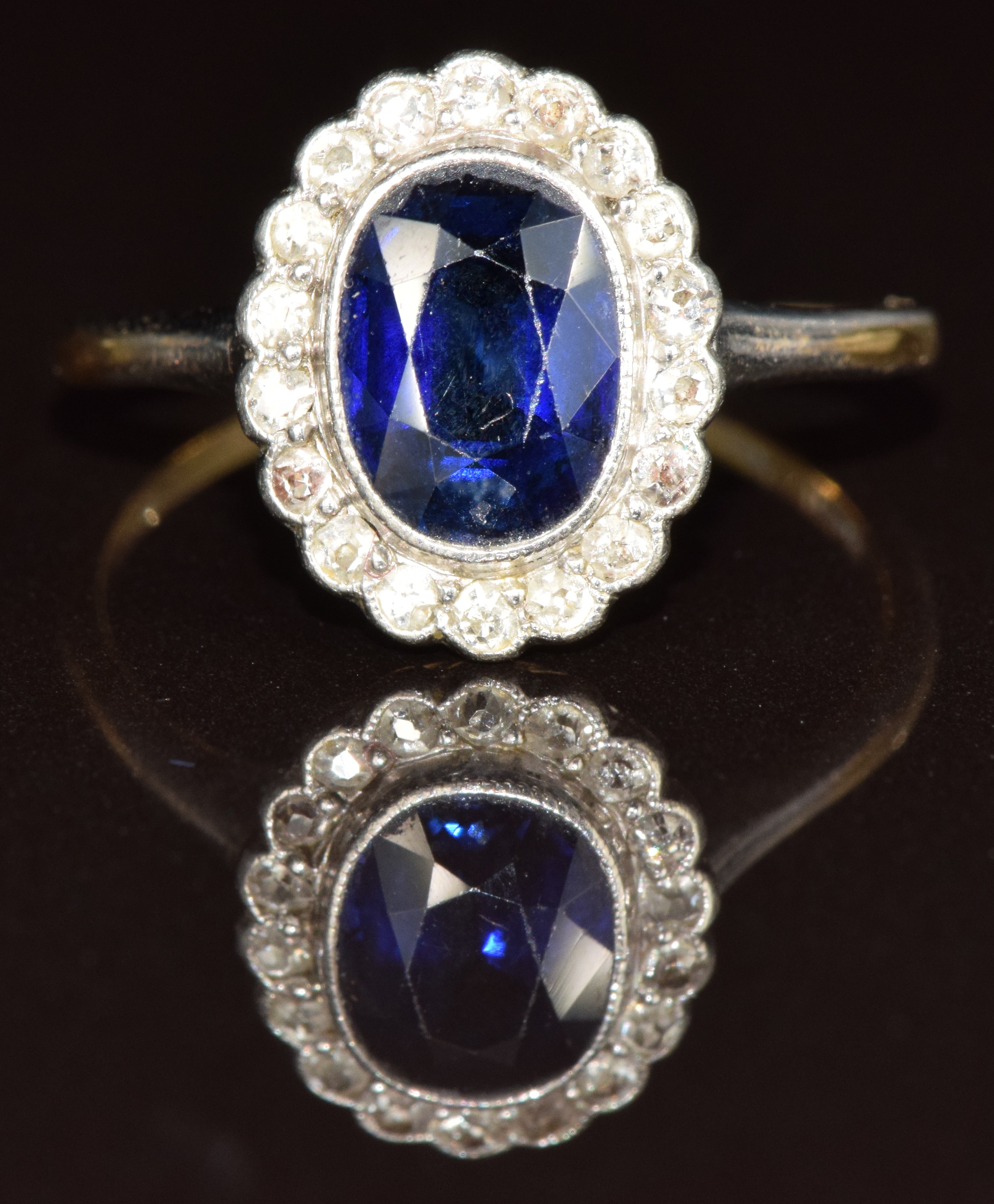 An 18ct white gold ring set with an oval cut sapphire of approximately 1.2ct surrounded by diamonds,