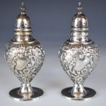 Pair of George V Victorian style hallmarked silver peppers with embossed decoration, Birmingham