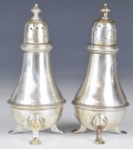 George V Goldsmiths & Silversmiths Co Ltd pair of hallmarked silver peppers, each raised on three