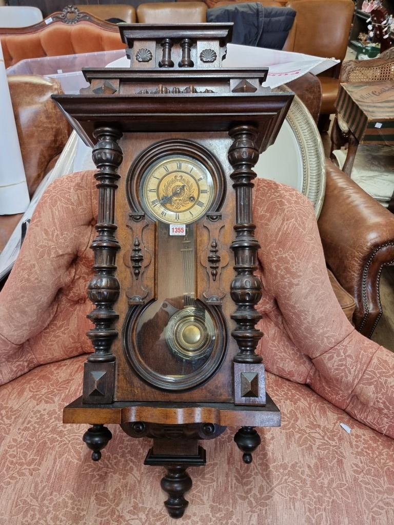 An antique walnut Vienna style wall clock, spring driven, 92cm high, with pendulum.