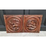 A pair of relief carved oak panels, each decorated with a dog, 51 x 47cm.