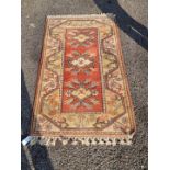 An Oriental rug, having three central medallions, with floral borders, 146 x 85cm; together with