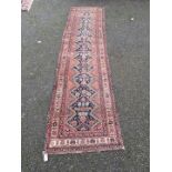 A Persian runner, having central diamond with floral and geometric design, with floral borders on
