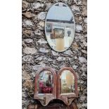 A 1920s oval wall mirror, 43 x 28cm; together with a small pair of oak framed girandoles, 32.5cm