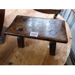 An old oak milking stool, the base stamped 1942, 25.5cm wide.