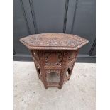 An Indian carved and pierced hardwood octagonal folding table, 61cm wide.