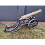A brass and cast iron table canon, on two wheel carriage, the canon 29cm long.