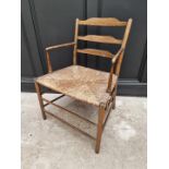 An antique ash and rush seated Sussex style elbow chair, with ladder back.