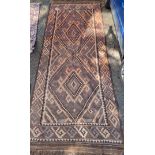 An Afghan Kelim rug, having two geometric medallions, 407cm x 165cm.