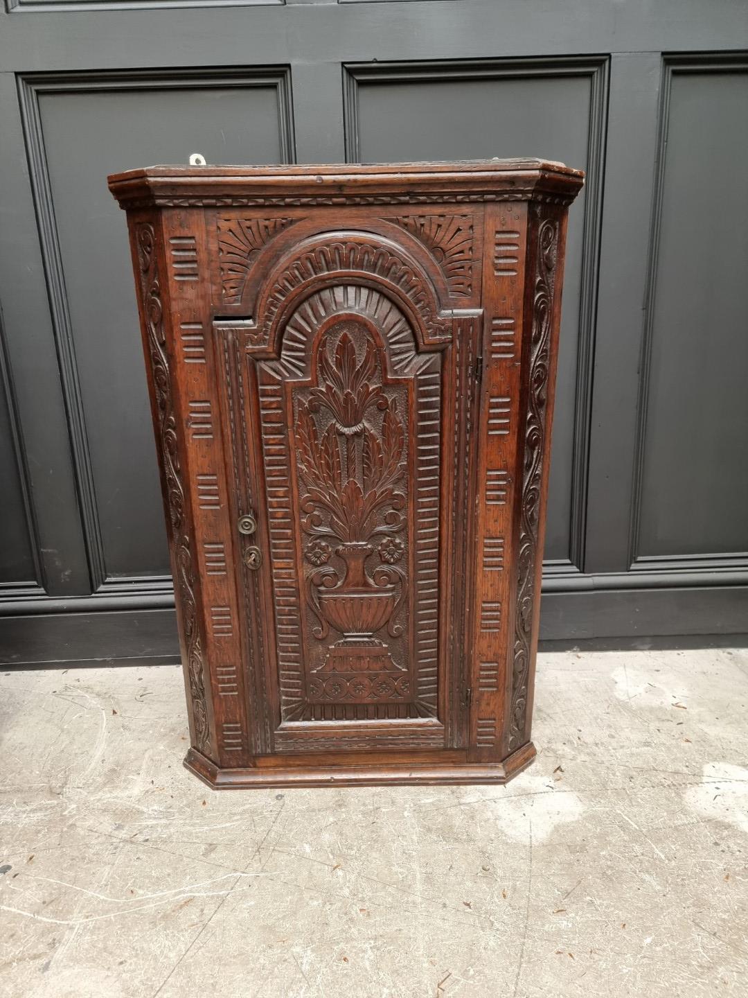 A George III oak and mahogany crossbanded hanging corner cupboard, 107.5cm high x 92cm wide;