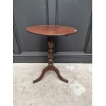 An early 19th century mahogany and oak circular tilt top tripod table, 48cm diameter.