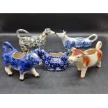 Five pottery cow creamers, to include an interesting 19th century Prattware example with milkmaid,