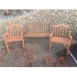 A teak garden bench; together with a pair of teak armchairs.