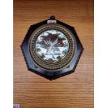 A 1920s brass framed sorcerer's or witch mirror, on stained and carved wood octagonal mount, 21.