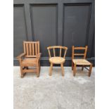 Three child's chairs, comprising two oak examples; and another beech and rush seated example.