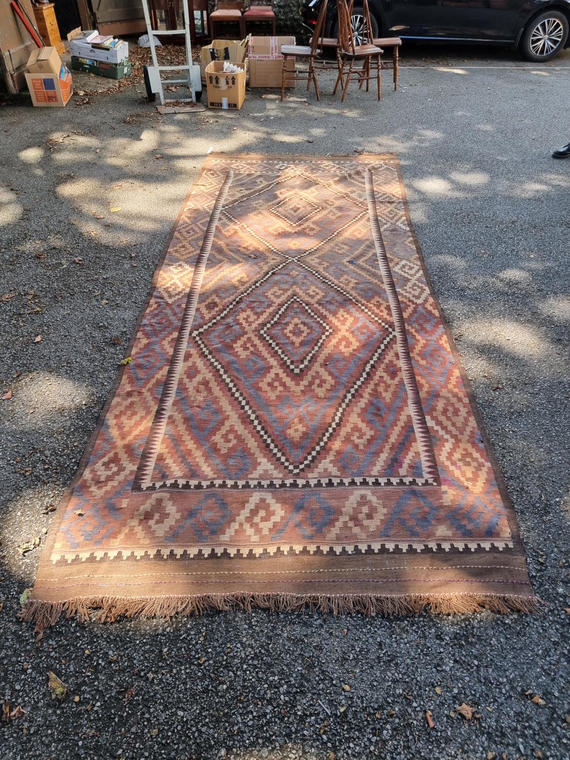 A large Afghan Kelim carpet, having two geometric medallions, 407cm x 165cm, (a.f.).