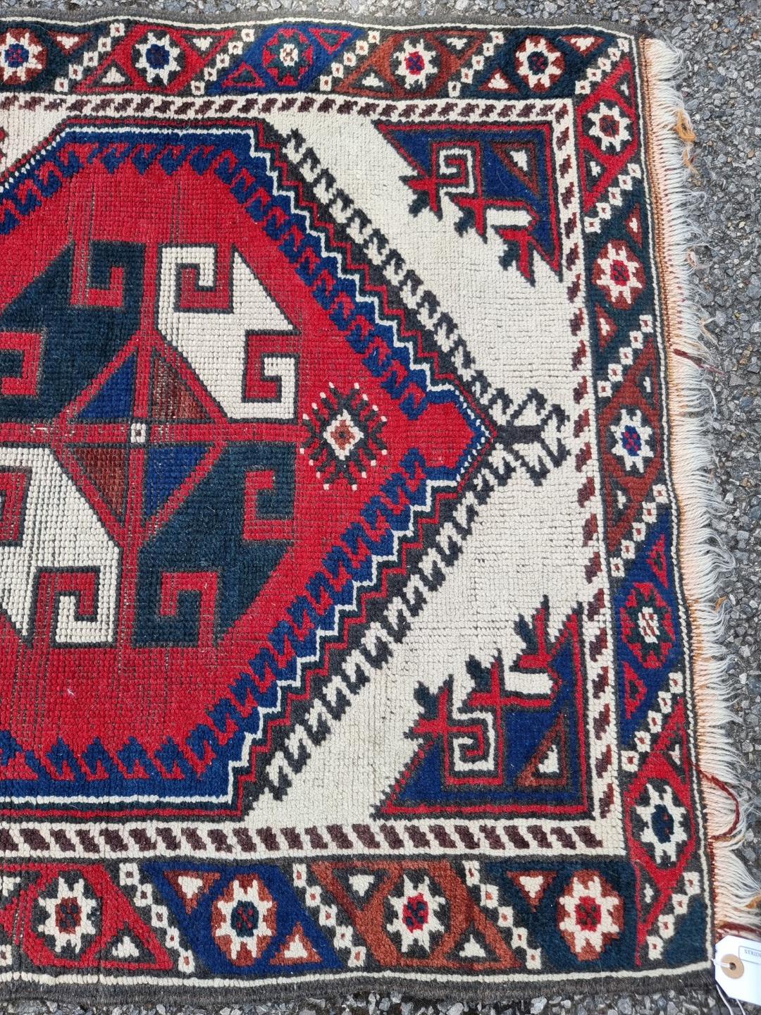 A small tribal rug, with floral borders, 119 x 76cm wide; together with another similar rug, 110 x - Image 2 of 5
