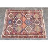 A Persian rug, having twelve geometric medallions, central field with floral decoration and