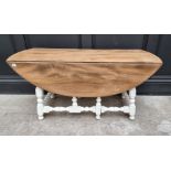 An elm and white painted gateleg low occasional table, 106cm wide.