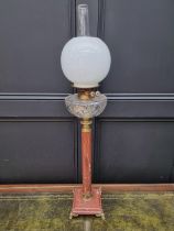 A red marble and brass mounted oil lamp, height excluding chimney 79.5cm.