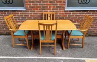 An Ercol elm dining table and four chairs, to include a pair of elbow chairs, the table 152.5cm