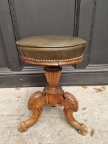 A Victorian carved walnut and brass studded leather adjustable tripod piano stool.