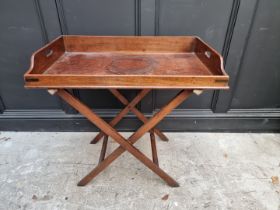 An early 19th century mahogany and brass bound butler's table, 84cm wide, on folding stand.