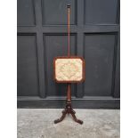 A Victorian mahogany tripod polescreen.