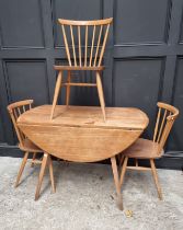 A vintage Ercol drop leaf table and three matching dining chairs, the table 125cm wide when open, (