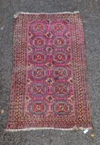 A Persian rug, having repeated gul design to central field, with geometric borders, on a red ground,