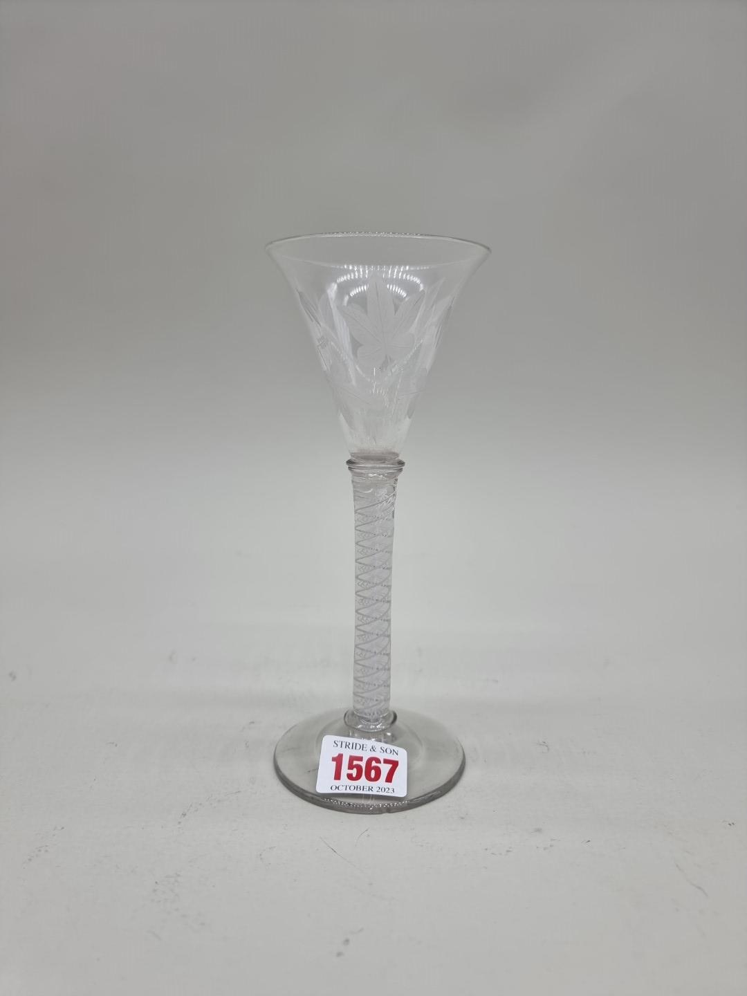 An 18th century opaque twist wine glass, the bowl etched with leaves, 18cm high.