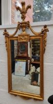 A reproduction gilt framed wall mirror, in the neo classical style, 124 x 61.5cm.
