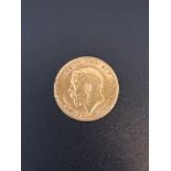 Coins: a George V 1911 gold half sovereign.