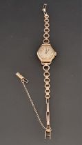 A 9ct gold ladies manual wind wristwatch, on plated bracelet.