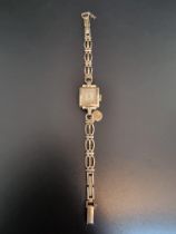 A vintage Tudor manual wind ladies wristwatch, stamped 10k 14mm, on a 9ct gold bracelet.