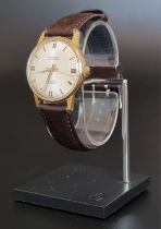 A vintage J W Benson gold plated manual wind wristwatch, 34mm, on leather strap.