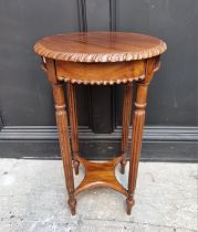 A reproduction carved hardwood circular occasional table, 39.5cm high.