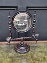 An antique turned fruitwood shaving mirror, with a pair of candle branches, 40.5cm high.
