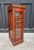 A vintage 'Su-Tall' mahogany haberdasher's chest, with a glazed panelled door enclosing eight