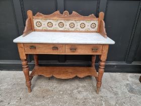 A late Victorian pine and marble top washstand, with tiled gallery back, 107cm wide.