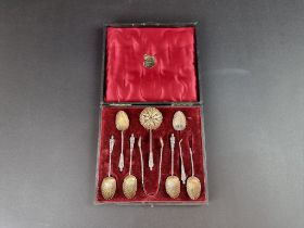 A cased set of six silver and parcel gilt coffee spoons, tongs and a sugar sifter, by H H & S,