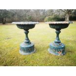 A pair of cast iron urns on pedestals attributed to the Handyside foundry
