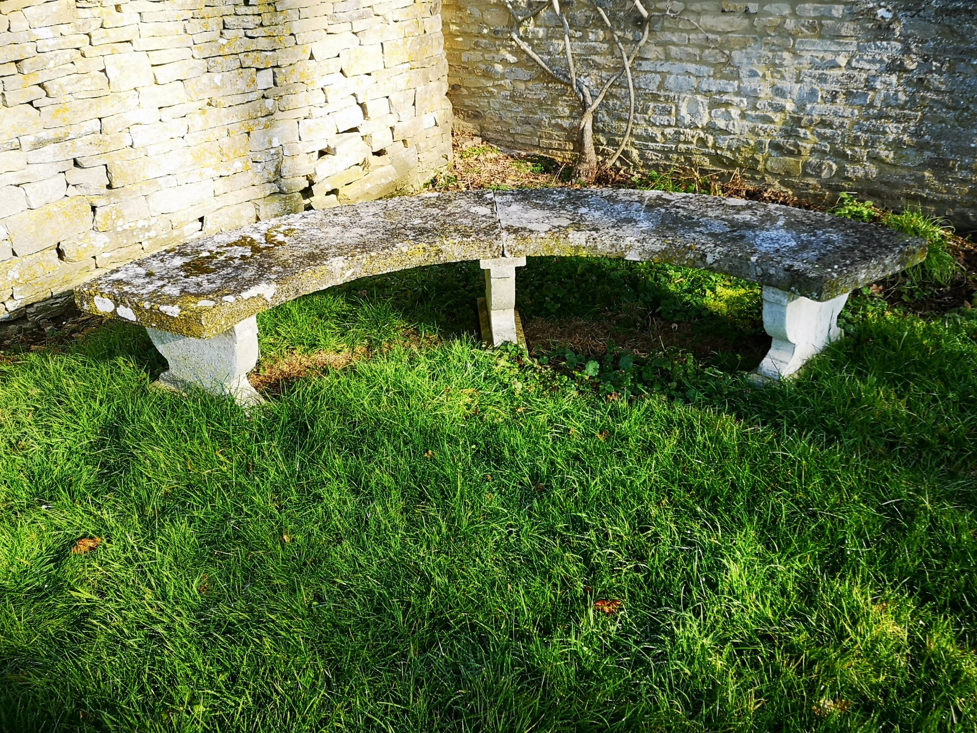 A carved Portland stone curved bench