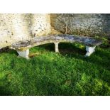 A carved Portland stone curved bench