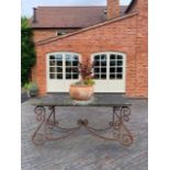 A wrought iron and sandstone table