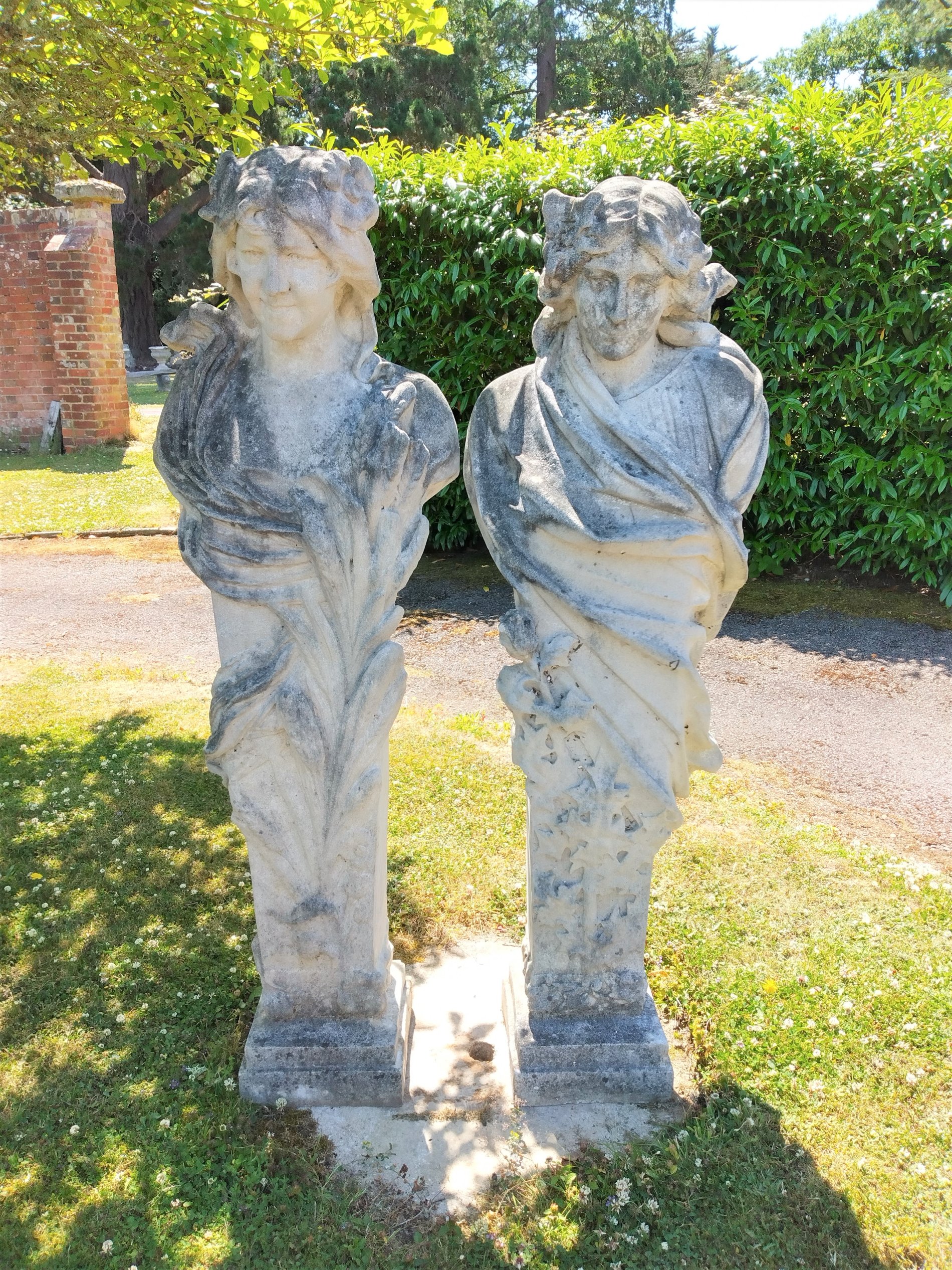 A pair of composition stone terms representing Summer and Winter